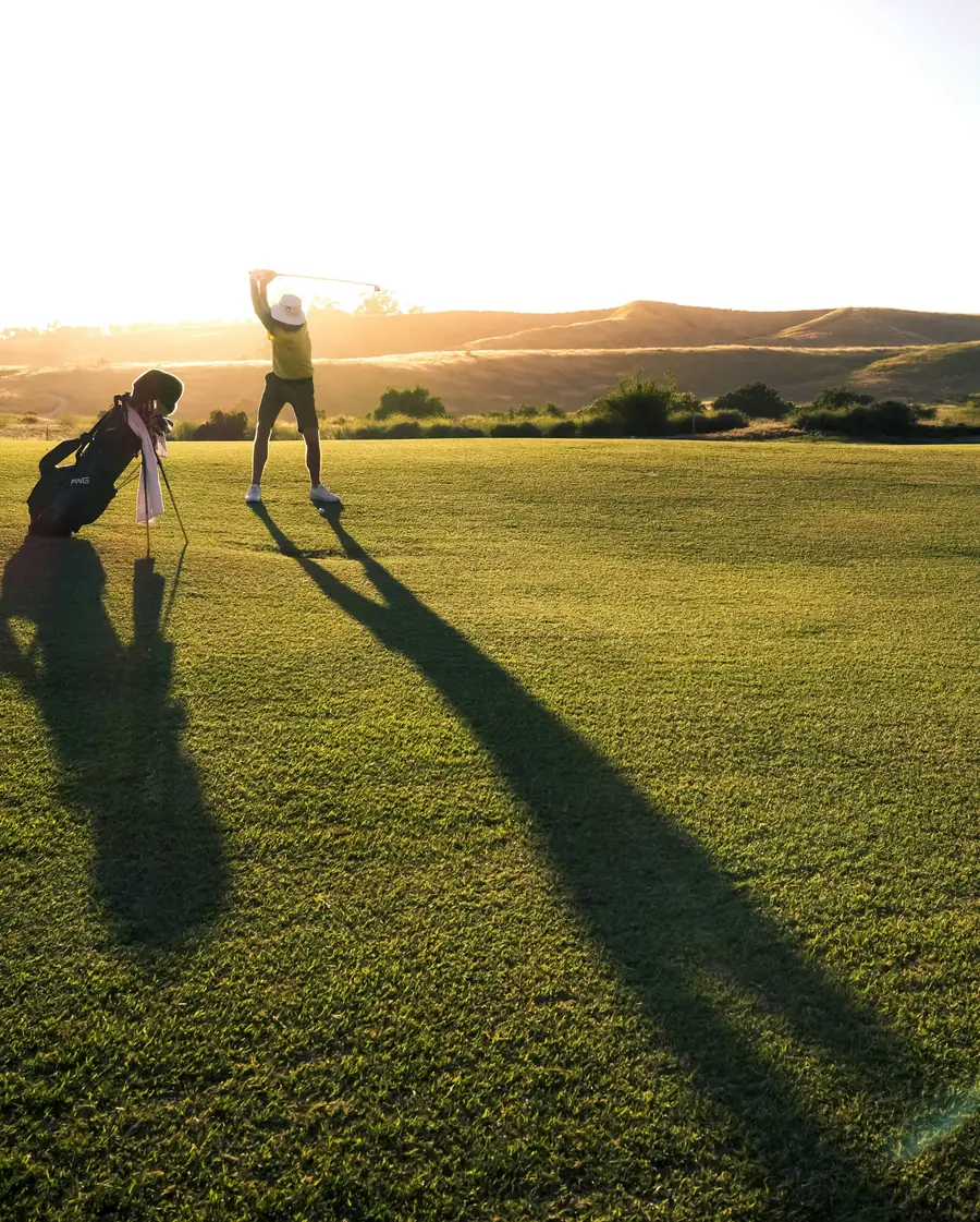 Golfista celebrando al atardecer