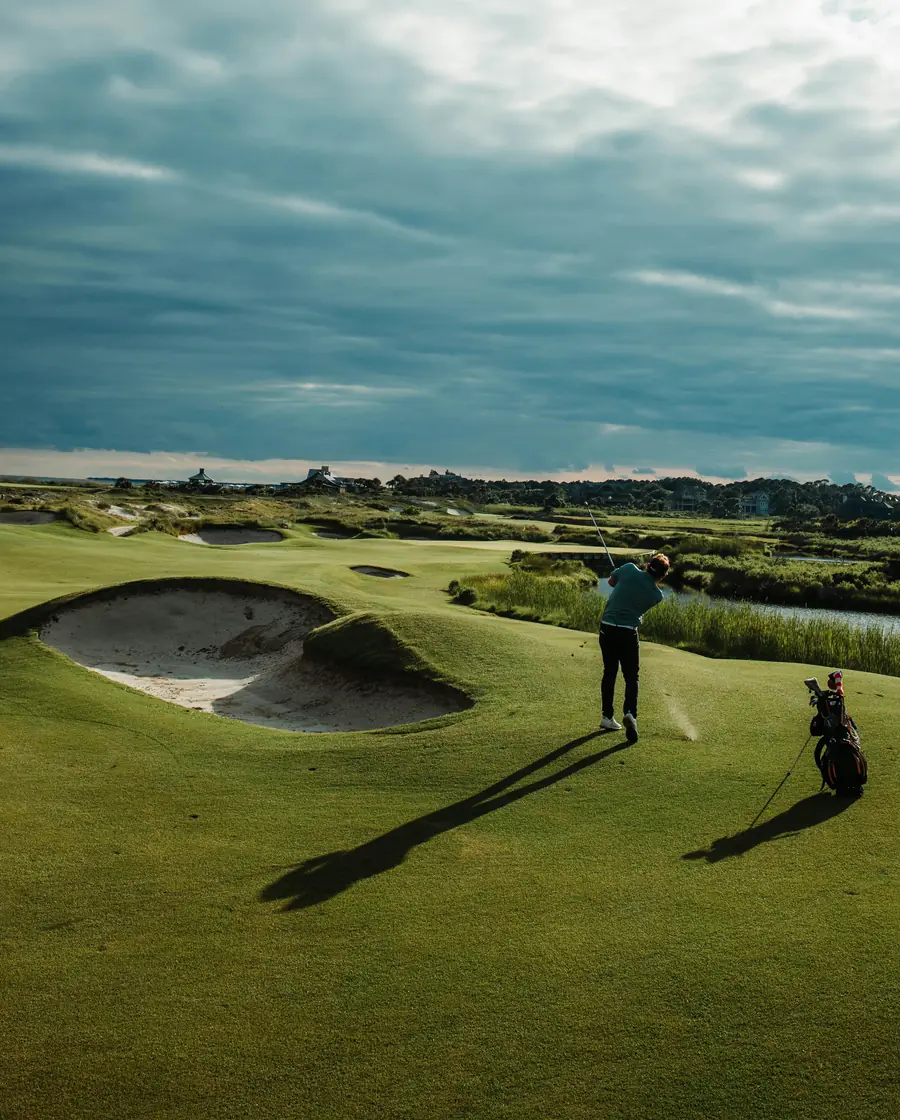 Golfista jugando en un campo junto a un búnker